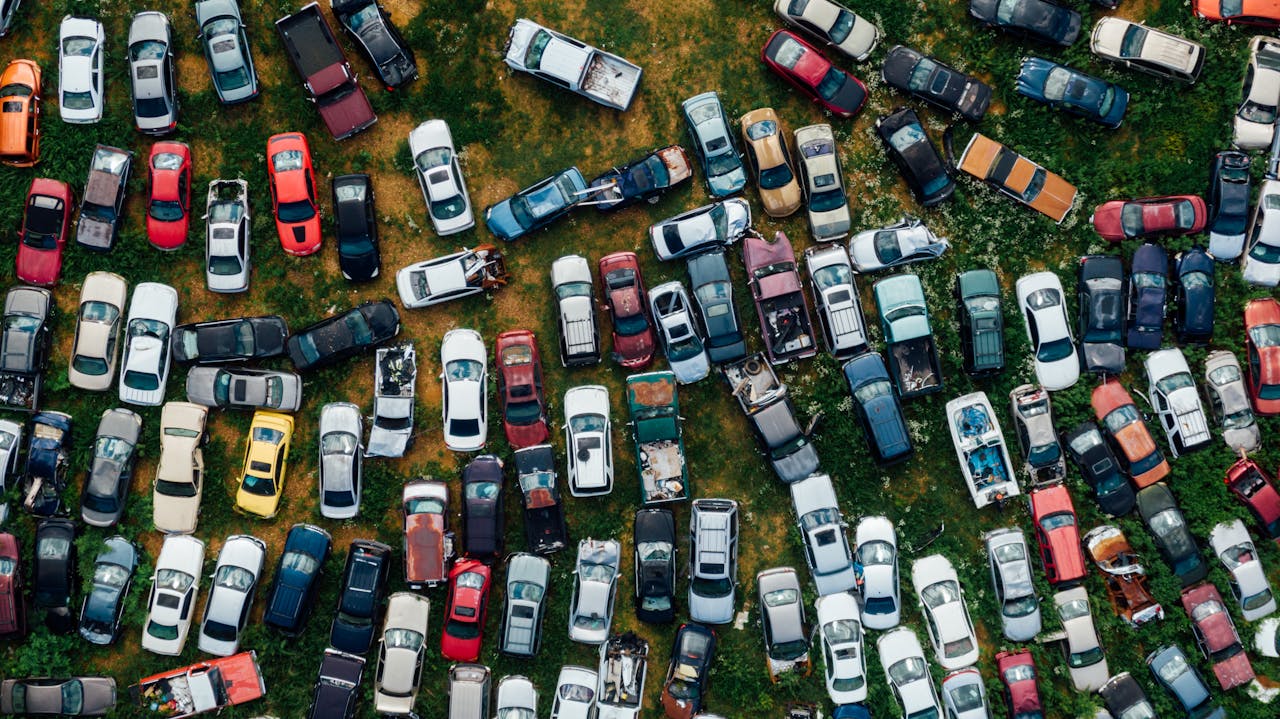 The Art of Drawing Readers In: Your attractive post title goes here A top-down view of vibrant, abandoned cars in a scrapyard, showcasing urban decay.
