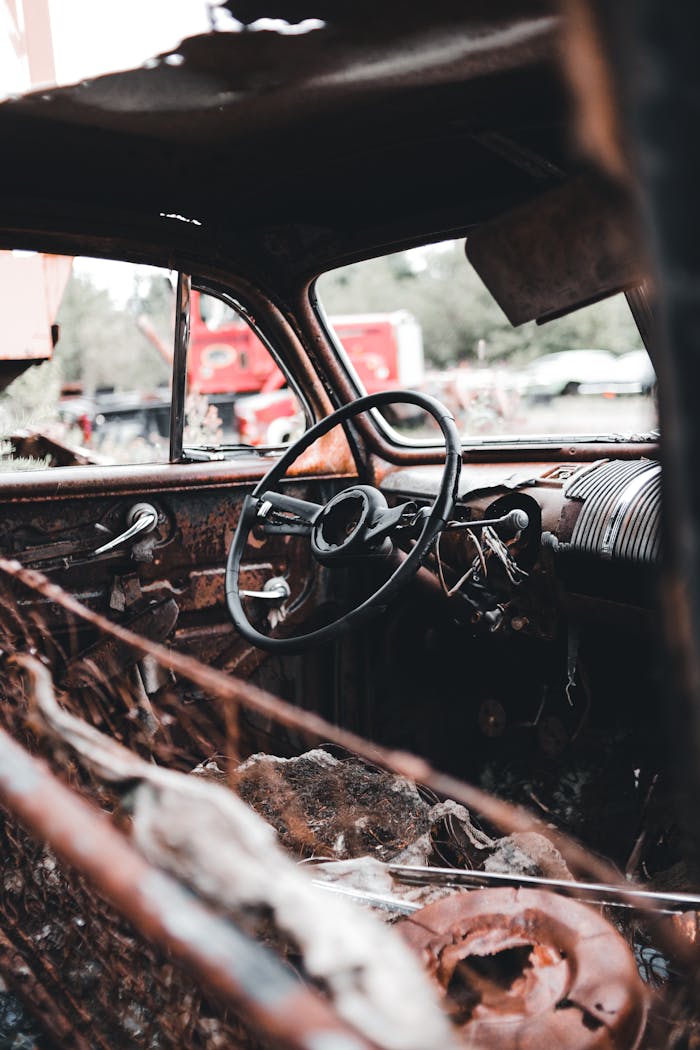 Services Rusty and decayed interior of an abandoned car in a junkyard.